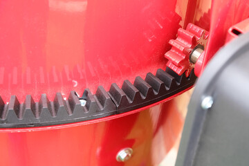 Fragment of a concrete mixer, view of the drive gear and polyamide crown close-up. Construction tool for preparing concrete mix.