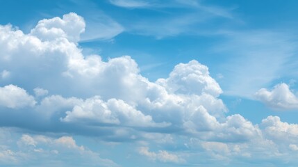 Beautiful fluffy clouds drift peacefully across a bright blue sky, creating a serene and uplifting atmosphere.