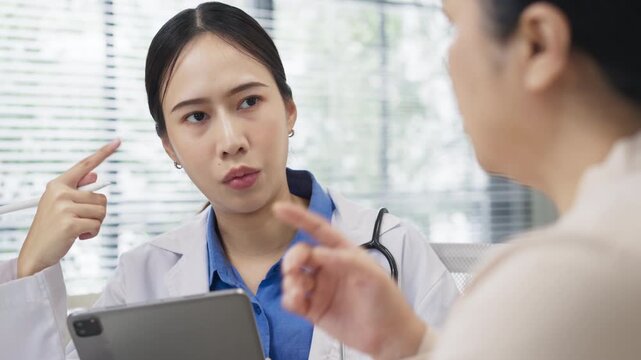 Asian doctor in uniform attentively assists a senior couple with medical paperwork in a hospital area, explaining health records and test results with care and professionalis senior health	