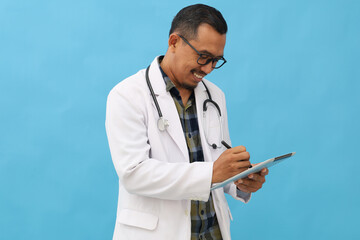 Asian adult male doctor wearing doctor's coat and stethoscope hanging on neck, standing smiling...