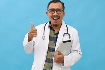 Asian adult male doctor standing wearing doctor's coat and hanging stethoscope around his neck...