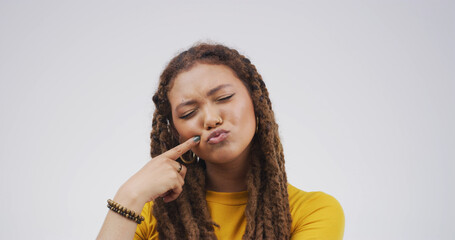 Touch cheek, silly and woman in studio for funny face, humor and comedy on white background. Cute,...