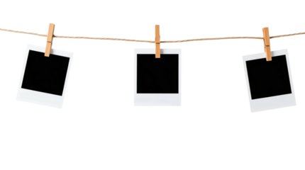 Three blank black polaroids hanging on wooden clothespins on a string isolated on transparent background