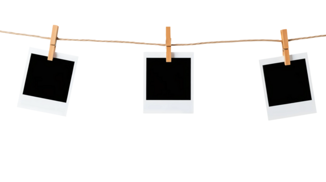Three blank black polaroids hanging on wooden clothespins on a string isolated on transparent background