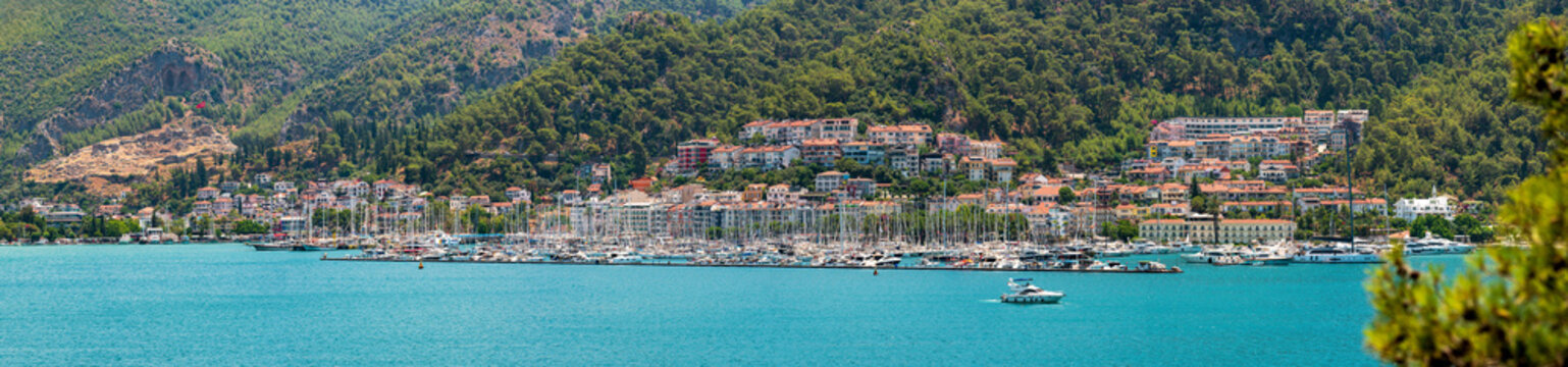 Panoramic view of colorful beach houses and a marina filled with yachts in Fethiye, Turkey
