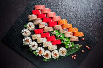 A vibrant sushi platter, arranged with flowers and greens, delights the eye