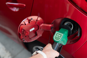 A red car being refueled with diesel