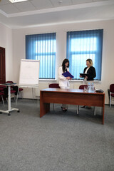 Two business women work in the office to solve problems and sign agreements.