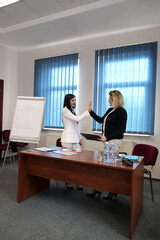 Two business women work in the office to solve problems and sign agreements.