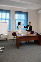 Two business women work in the office to solve problems and sign agreements.