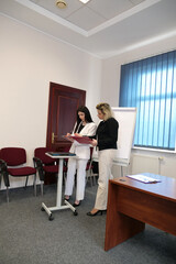 Two business women work in the office to solve problems and sign agreements.