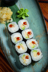 Delicate sushi rolls filled with creamy avocado and fresh fish, garnished with wasabi and ginger
