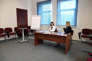 Two business women work in the office to solve problems and sign agreements.