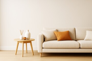 Fototapeta premium Minimalist modern living room interior with beige sofa, orange cushion, wooden table, and ceramic decor against light neutral wall background.