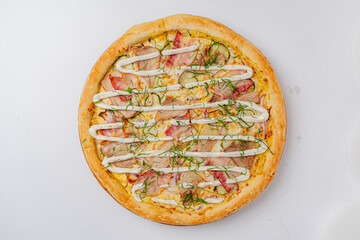 A gourmet pizza features tasty toppings like meats, fresh herbs, and drizzled sauce