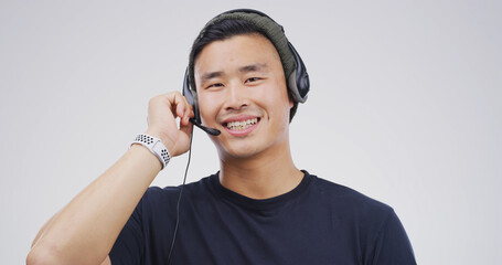 Asian man, portrait and headset in studio for telemarketing, sales and insurance advice in call...
