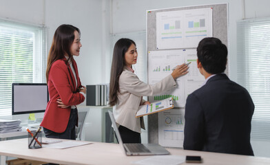 Professionals discussing financial charts and graphs during a team meeting in a bright, modern...