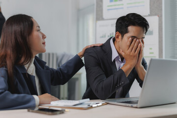 Businesswoman offering support to a stressed colleague in an office setting, highlighting workplace empathy and teamwork during challenging times