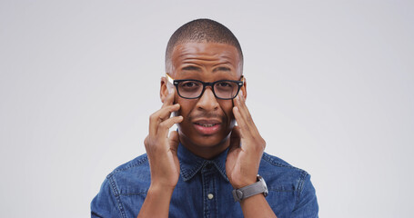 Black man, headache and glasses in studio portrait with mockup space, tired or vertigo on white...