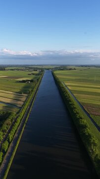 Amsterdam rhine canal, at Weesp, The Netherlands. Inland waterway, river. Shipping route. Vertical aerial video.