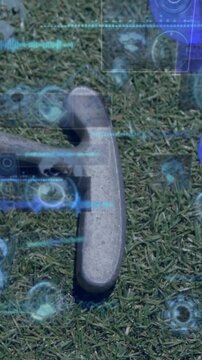 Hockey stick and ball on grass with digital data processing animation overlay