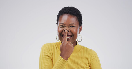 Touch nose, silly and portrait of black woman in studio for funny face, humor and comedy on white...