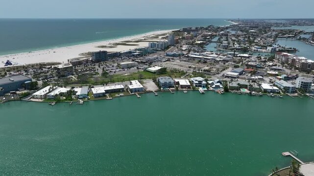 Treasure island with bay water, river, channel and sandy beach in summer. Aerial wide shot. Luxury houses and villas with marina pier in USA. Panorama view.