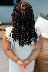Young mixed race girl having her hair braided
