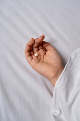 Child hand under blanket with milk tooth.
