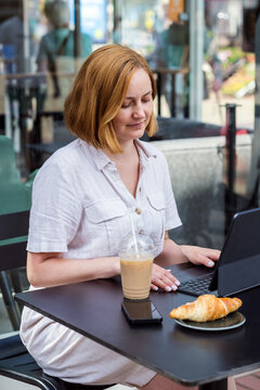 Freelancer woman working on laptop at a caffe