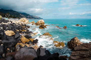 Rocky Coastline with Turquoise Sea and Mountains