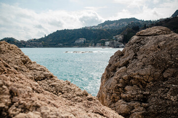 Rocky Coastline with Distant Hills and Clouds