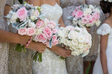 Bridal Party Holding Soft Pink and White Rose Bouquets Outdoors