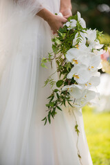 Bride Holding Cascading White Orchid Wedding Bouquet