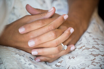 Bride’s Folded Hands with Diamond Ring on Lace Robe