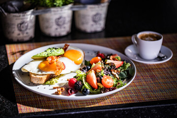 Healthy Breakfast with Fried Egg on Toast and Salad with Fruit