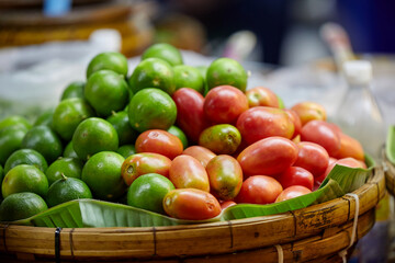Fresh lime and tomato in wicker basket