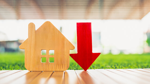 Image of house with down arrows. Concept of house prices. House construction prices and real estate prices can fluctuate and fluctuate. Risk control is important.