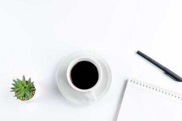 Office Desk With A Cup Of Coffee, Green Plant, Notebook, And Pen On A White Table For Office Supplies Content, Shot In Soft Natural Lighting With A Clean Minimalist Style.