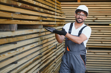 Woodworker showing lumber boards in warehouse