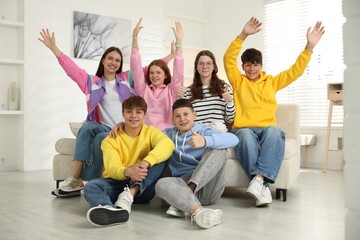 Group of excited teenagers on sofa at home