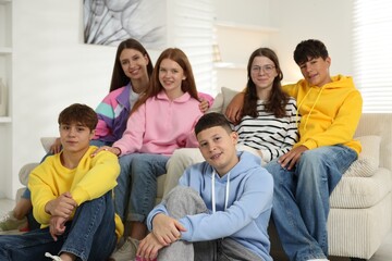 Group of happy teenagers on sofa at home