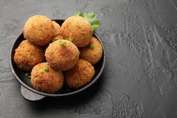 Delicious fried croquette balls with green onion on grey textured table, closeup. Space for text