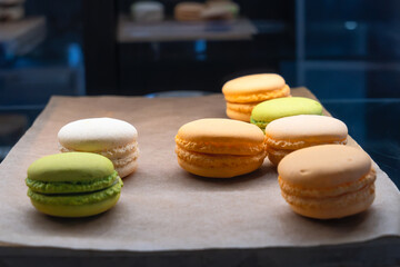 Vibrant Assortment Of French Macarons On Rustic Paper. Colorful French Macarons Displayed On Rustic Paper With A Variety Of Flavors.