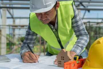 Engineers man recheck and review the blueprint of construction. Contractor inspection drawing...