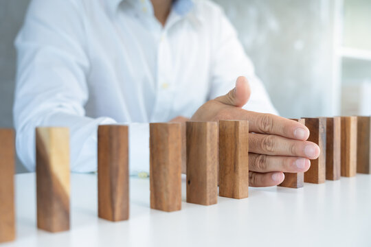 insurance with hands protect domino. Businessman hands stop dominoes falling in business crisis. business risk control and planning and strategies to run prevent insurance businesses.