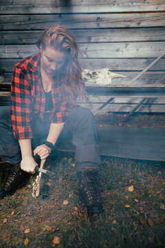 Bushcraft woman making wooden feather stick for fire in the wood