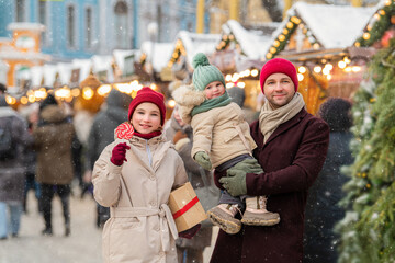father and two children stroll through a city Christmas market
