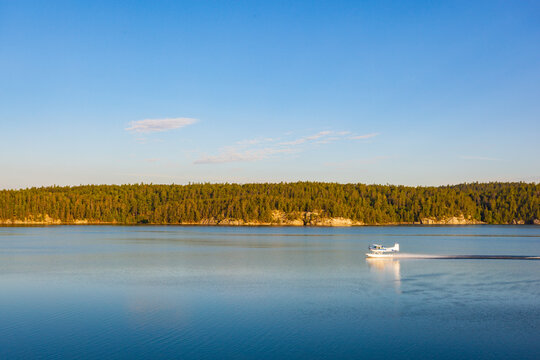 A float plane lands on the calm surface of Lake Temagami at sunrise