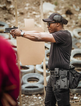 A man aims a gun at a target at a shooting range